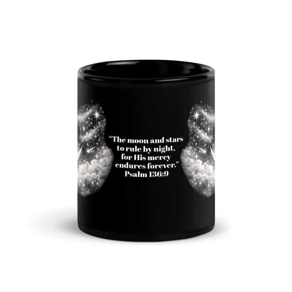black ceramic mug featuring a silver crescent moon and stars design on each side, with the Bible verse "The moon and stars to rule by night, for His mercy endures forever. Psalm 136:9" printed in white text on the center. 