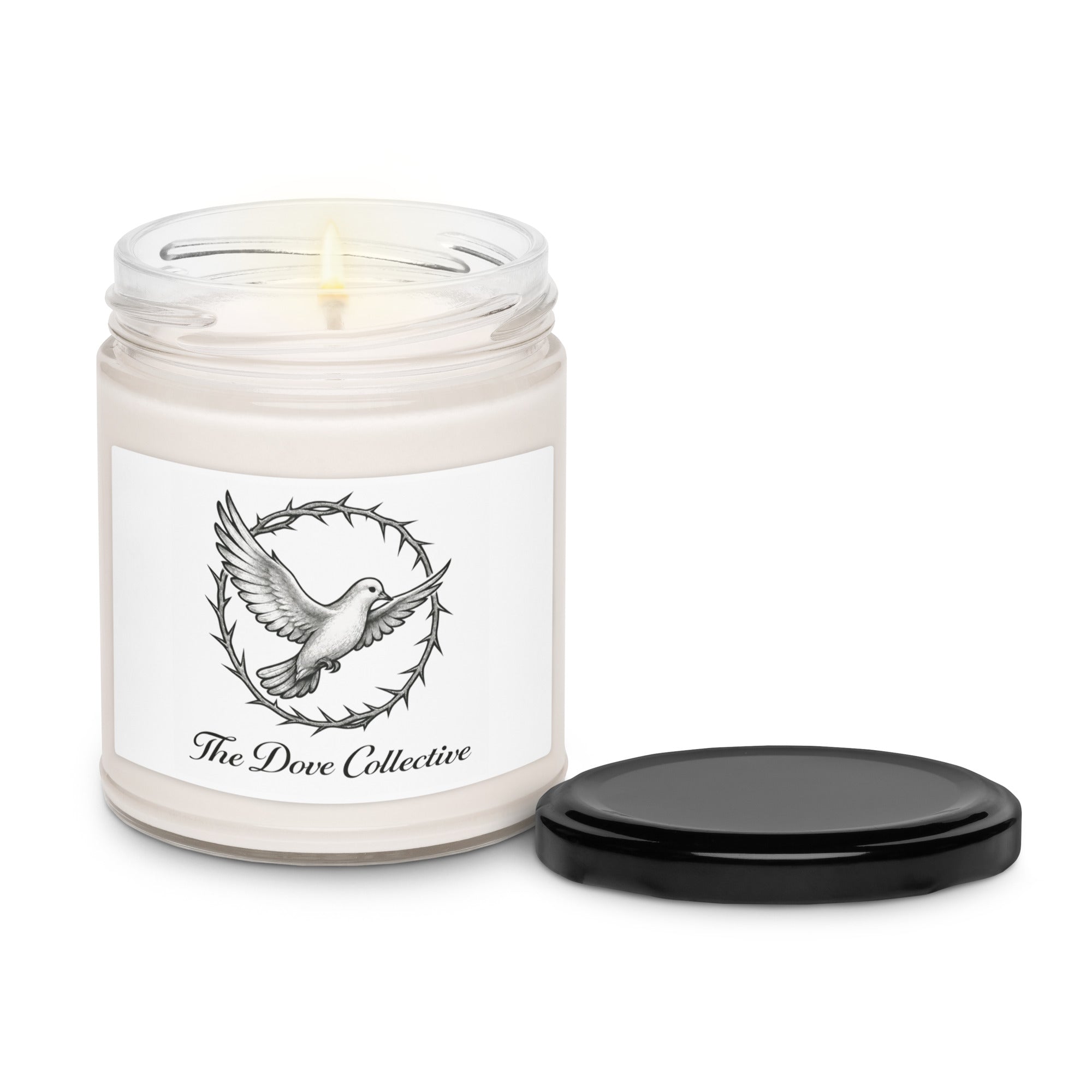 front view of a lit candle with a dove flying through a crown of thorns with "The Dove Collective" written underneath. black lid for the candle on the right side all on a plain white background. 