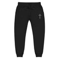 Black jogger pants with a white cross design on a white background