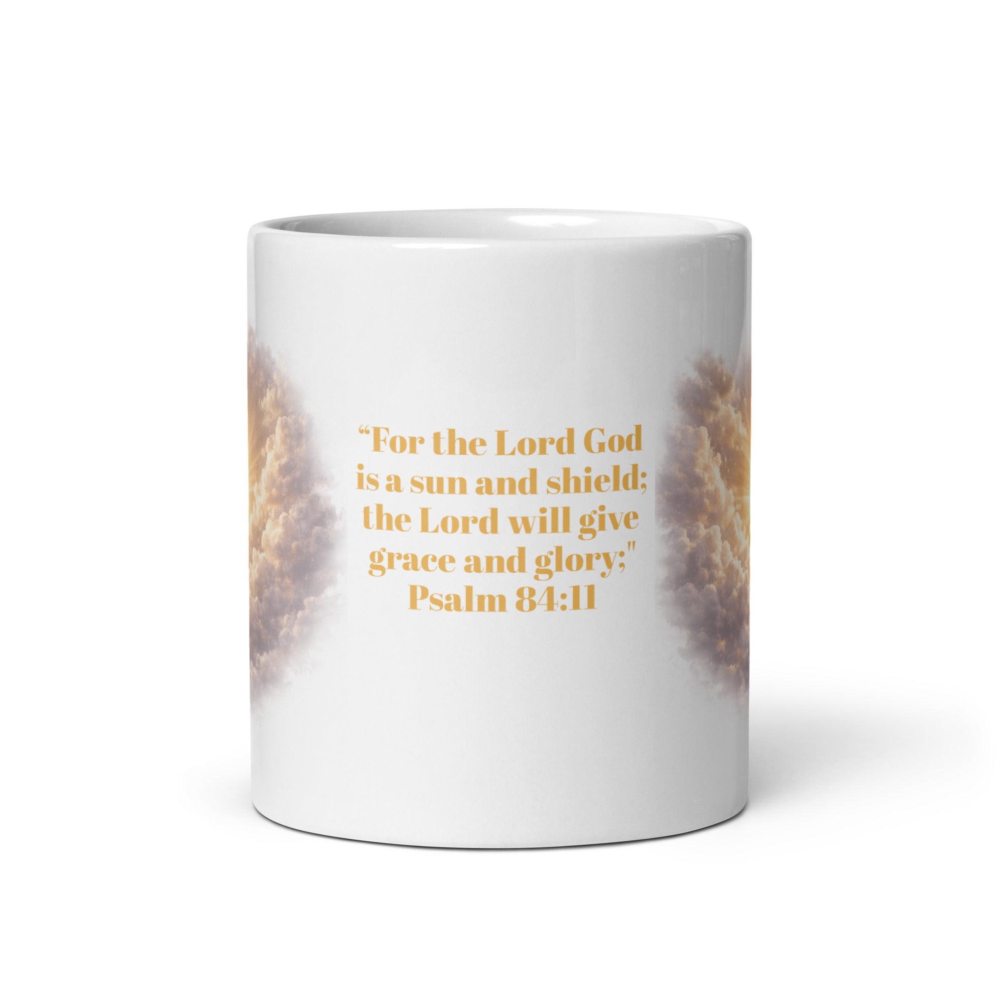 white ceramic mug featuring a golden scripture quote that reads, "For the Lord God is a sun and shield; the Lord will give grace and glory. Psalm 84;11" with radiant clouds and sunlight artwork wrapping around the sides. 