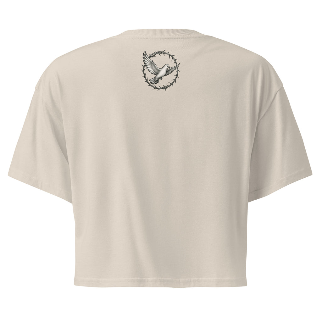  back of a bone-colored cropped Christian t-shirt featuring a small white dove centered between the shoulders surrounded by a circular crown of thorns design. 